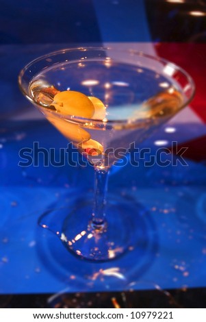 an image of a martini with olives in it with a red, white and blue background