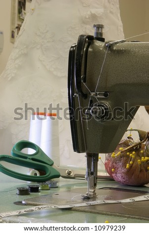 stock photo Antique sewing machine with wedding dress background stock photo Antique sewing machine with wedding dress background