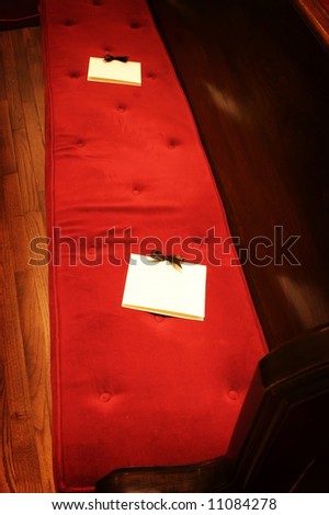 stock photo an image of formal wedding programs on a red church pew
