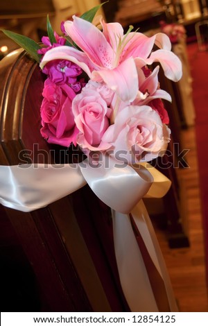 stock photo Wedding flowers in a church on the end of a pew