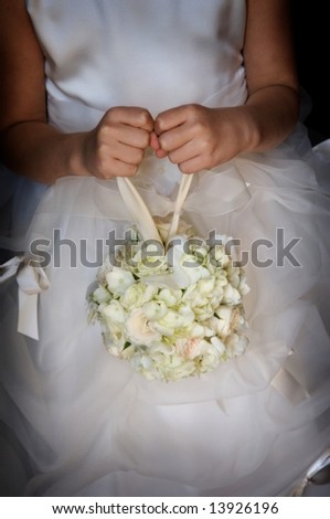 An image of a flower girl holding her floral bouquet