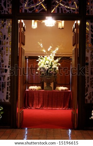 An image of a luxurious table setting with a large flower arrangement and wedding programs