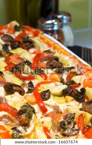 An image of Mediterranean pizza with peppers, artichokes, mushrooms and more
