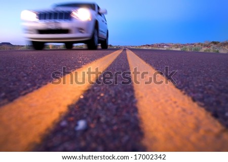 An abstract image of desert highway with a car whizzing by