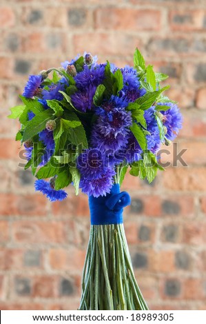 A colorful purple bridal bouquet of flowers with mint leaves