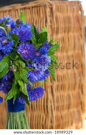 A colorful purple bridal bouquet of flowers with mint leaves