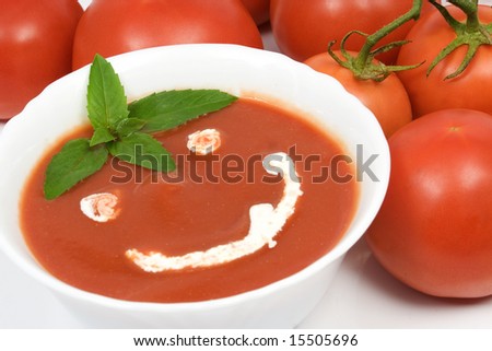 Tomato soup with basil leafs and sour cream as decoration