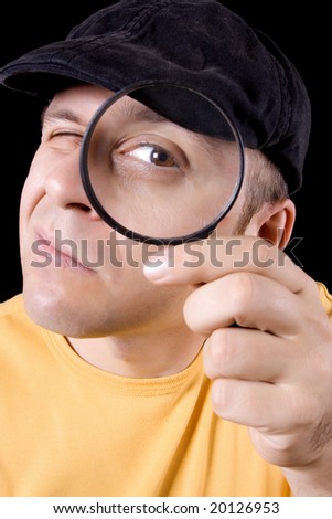 Detective with magnifying glass on black background