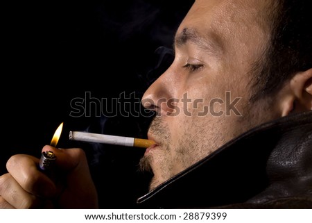Young man in a leather jacket smoking a cigarette