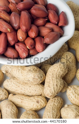 Roasted peanuts served in a bowl with peanut shells as background