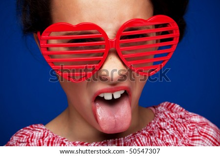 Young girl with heart shaped shutter shades sticking her tongue out