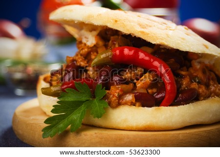 Mexican chili beans sandwich garnished with parsley and hot peppers