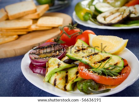 Barbecued zucchini, tomato and onion served on a plate