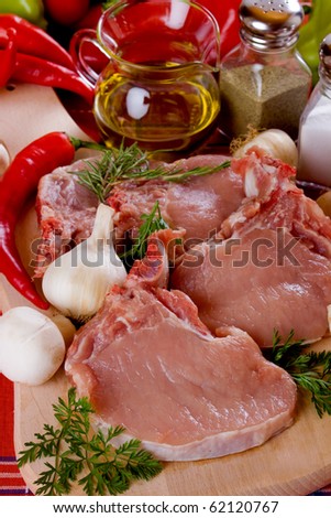 Raw pork loin chops meat on wooden chopping board