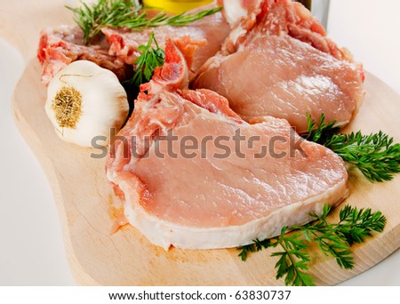 Raw pork loin chop meat on wooden chopping board