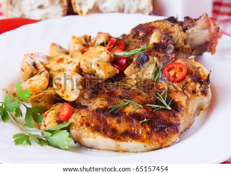 Grilled pork loin chops served with mushrooms and chili peppers