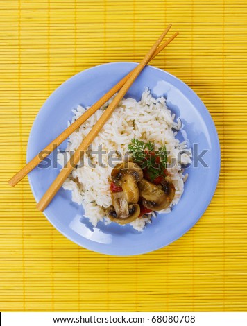 Chinese cooked rice with mushrooms served with chopsticks