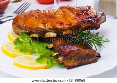 Honey glazed barbecued ribs with lettuce and lemon slices