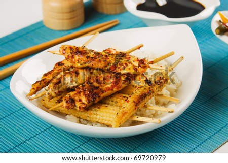 Asian chicken meat and baby corn on skewer with cooked rice