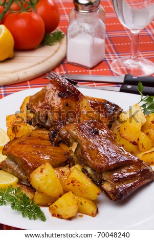 Barbecued ribs served on a plate with baked potato