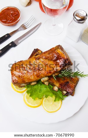 Honey glazed barbecued ribs with lemon and lettuce