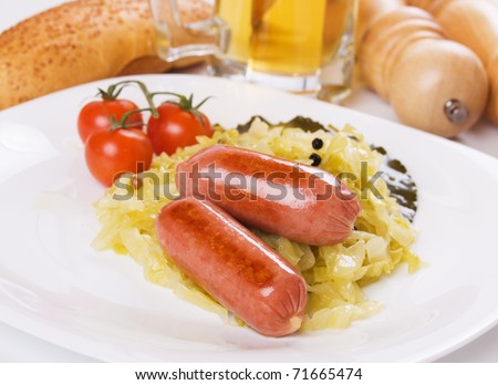 Fried sausage and sauerkraut on white plate, traditional german food