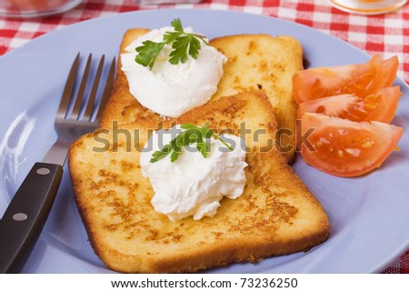 French toast served with tomato and cream on a plate