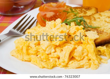 Scrambled egg served with french toast and tomato