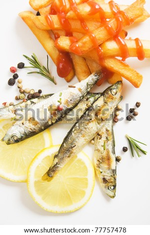 Grilled sardine fish with french fries and lemon slices