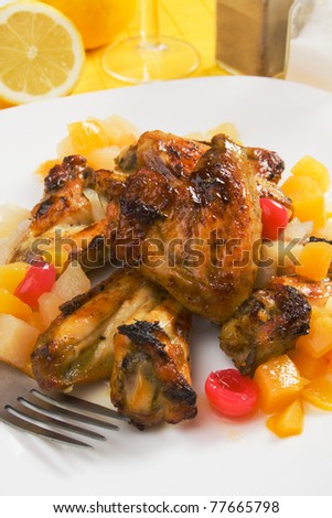 Grilled chicken wings served over tropical fruit