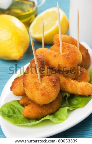 Breaded shrimp snack served as party food with lemon and lettuce