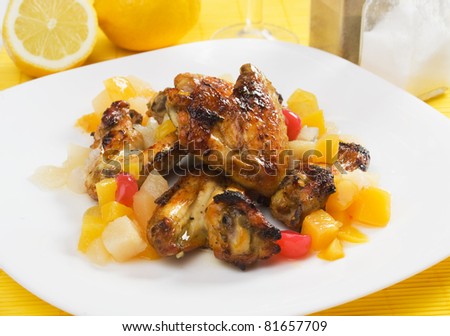 Grilled chicken wings served with tropical fruit