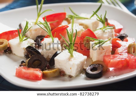 Cheese, tomato and olives salad with rosemary and olive oil