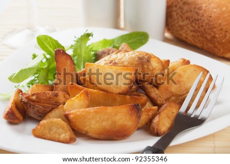 Roasted potato wedges with lettuce on a plate