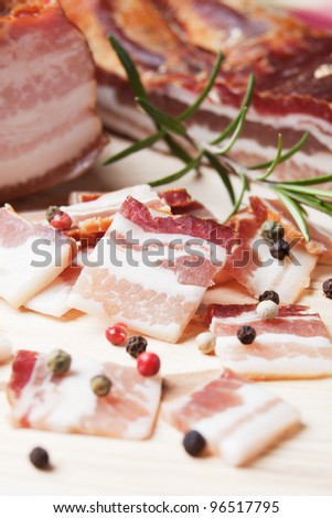 Smoked bacon, pork meat cut in slices on wooden board