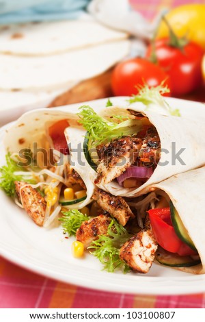Grilled chicken meat and vegetable salad in tortilla wrap
