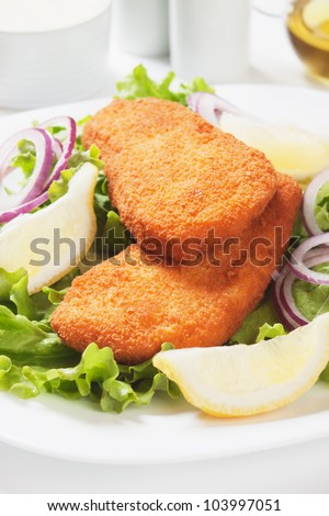 Breaded fish with lettuce and lemon salad