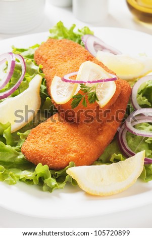 Breaded fish steaks with lettuce and lemon salad