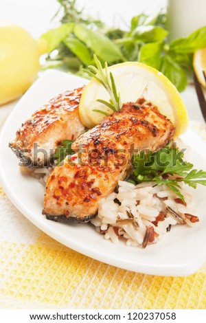 Grilled salmon steak with cooked rice, herbs and lemon