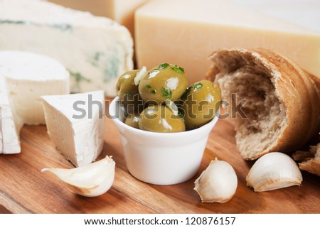 Pickled green olives with cheese, bread and garlic