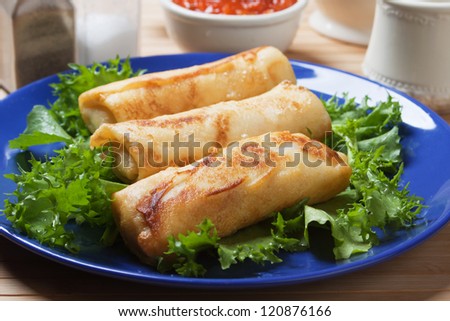 Chinese egg rolls with lettuce and red sauce