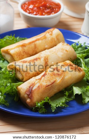 Chinese egg rolls with lettuce and red sauce