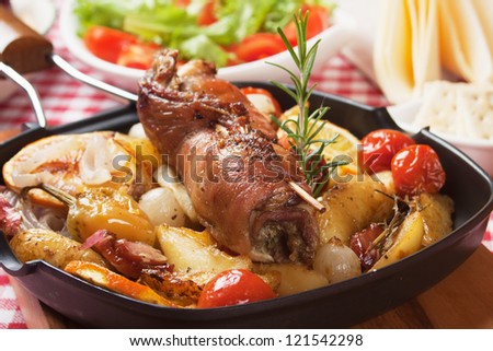 Rolled meat oven roasted with potatoes, orange and vegetables