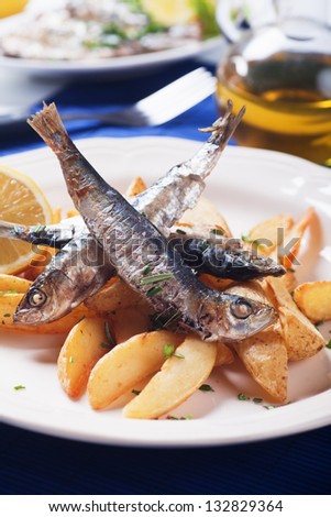 Grilled sardine fish with fried potato wedges