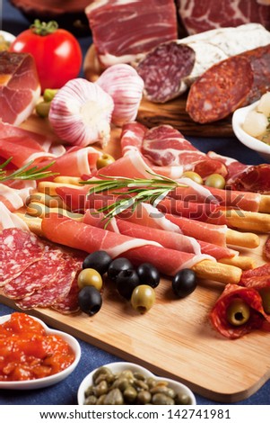 Italian prosciutto, cured pork meat on cutting board