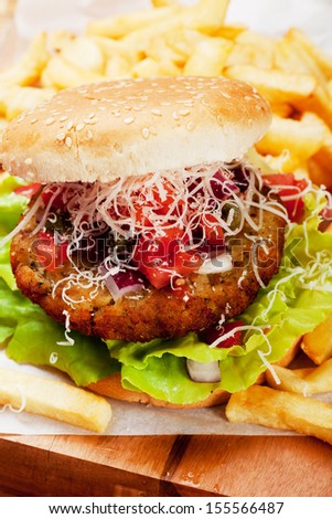 Classic hamburger with tomato and grated cheese, served with french fries