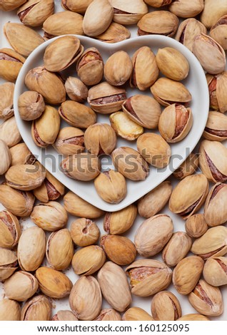 Roasted pistacchio nuts, healthy snack in heart shaped tray
