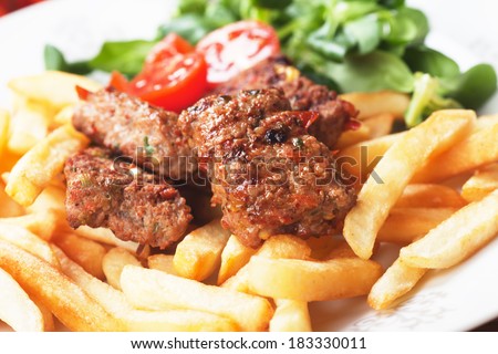 Square burgers, spicy barbecued bites with french fries and salad