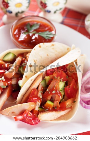 Chicken salad in tortilla wraps with tomato sauce and fresh vegetables