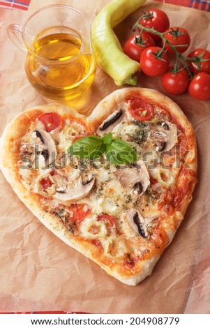 Heart shaped funghi pizza with hot peppers, classic italian recipe